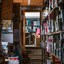 Cluttered storage room with shelves of supplies and a calendar on the wall.