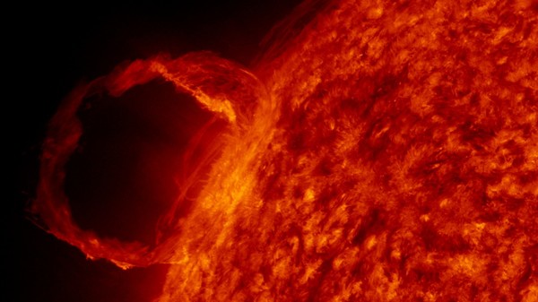 An image of plasma erupting from the Sun and flowing in a loop along a magnetic field line.