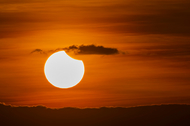 A partial solar eclipse, shortly after sunrise.